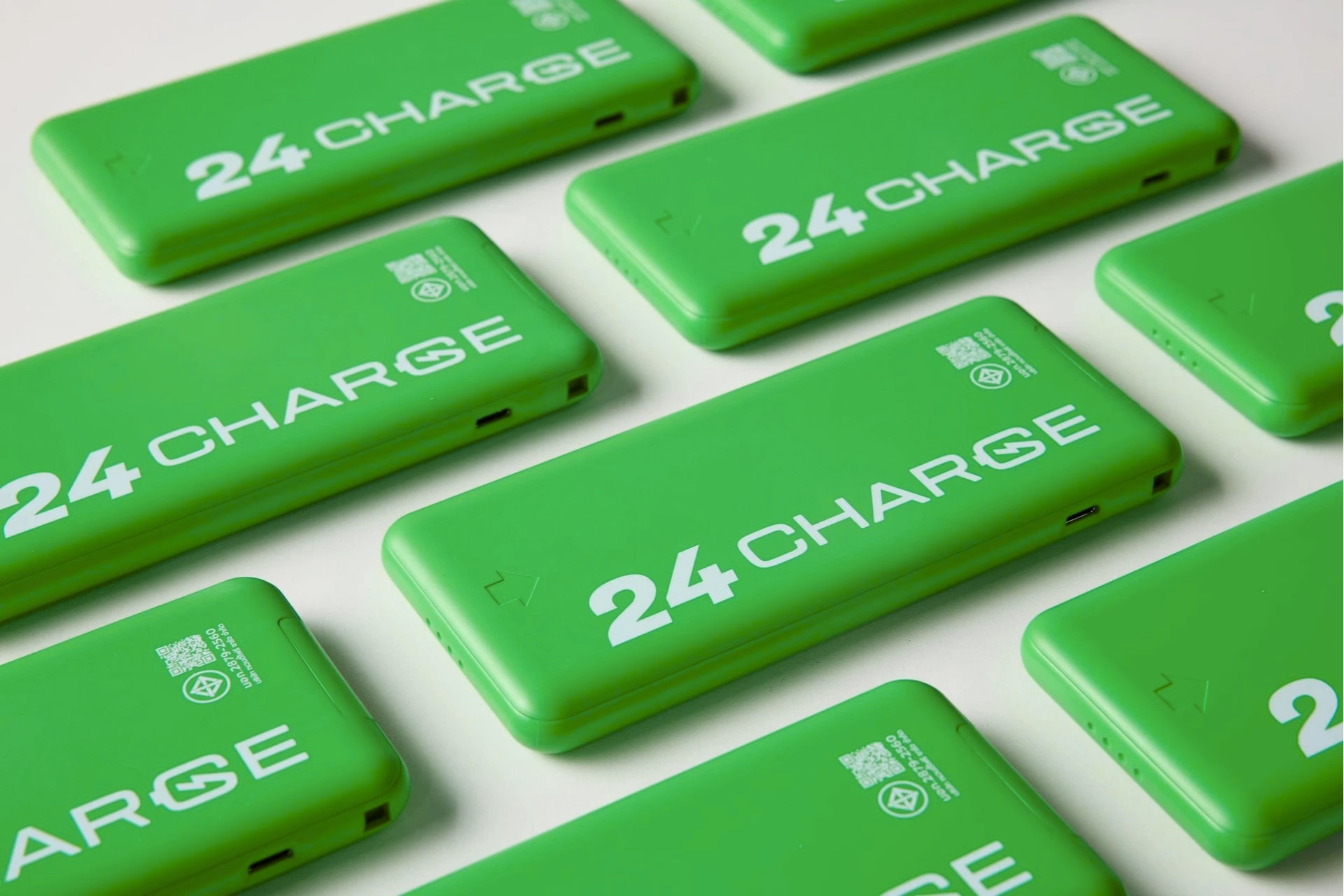 พาวเวอร์แบงก์ 24CHARGE สีเขียวเรียงเป็นตารางพร้อมโทรศัพท์มือถือ