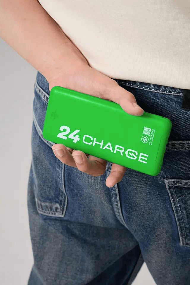 มือถือพาวเวอร์แบงก์ 24CHARGE สีเขียวไว้ที่สะโพก
